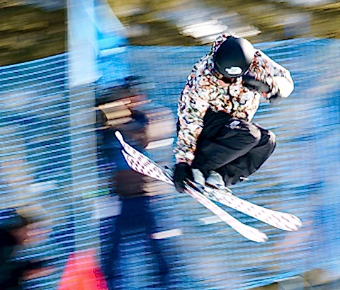 trick skier doing a grab trick over a ramp